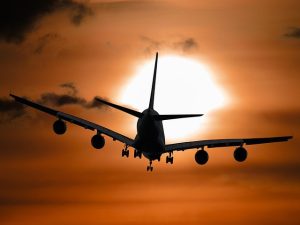 Airplane flying at sunset